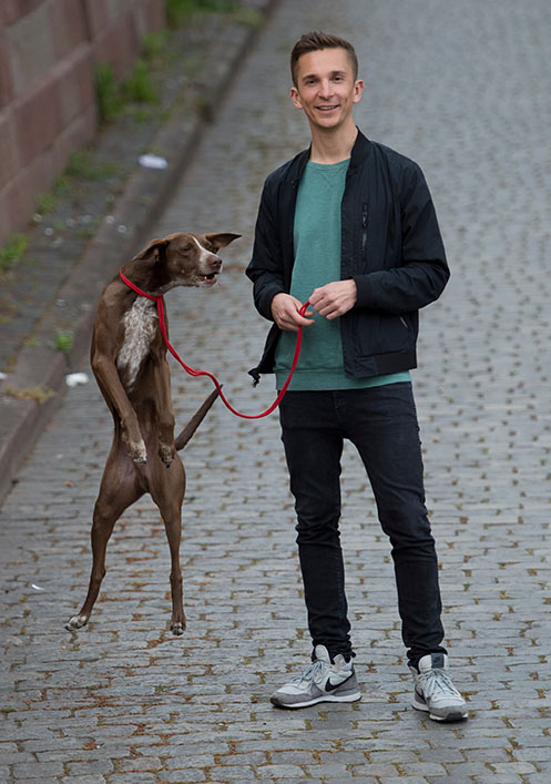 Kika-Moderator Eric Mayer und sein Hund Caramello wissen den roten Faden sinnvoll als Hundeleine einzusetzen, aufgenommen am Mittwoch (29.04.2015) am Mainufer in Frankfurt am Main.